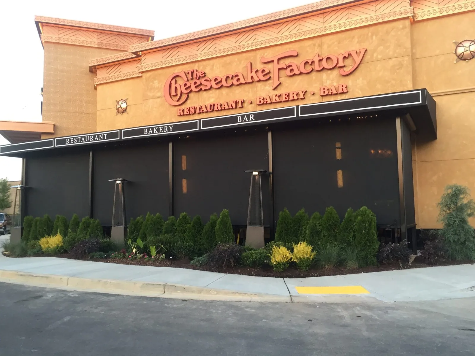 Motorized screens and patio heaters keeping a Cheesecake Factory patio in service