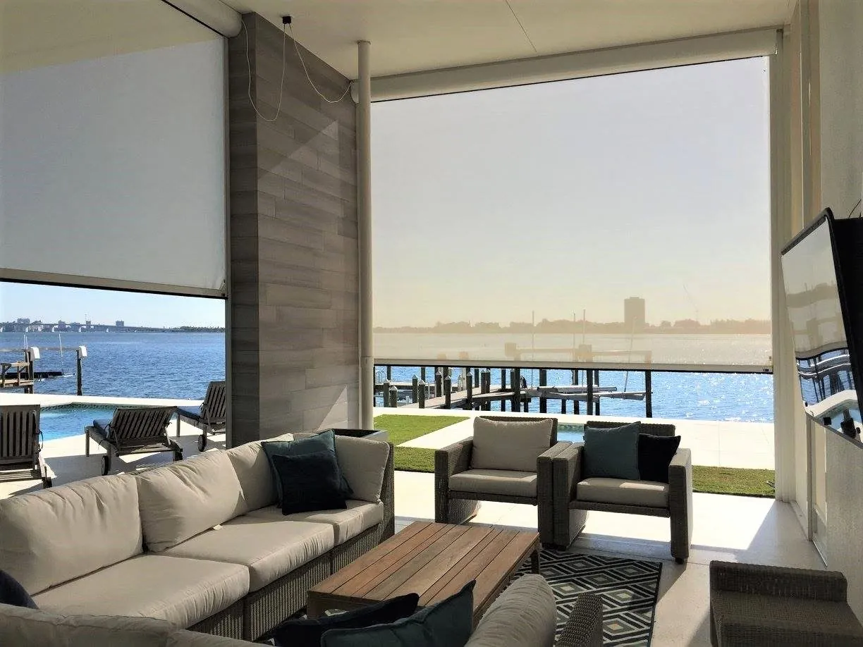 Motorized screens enclosing a corner porch on a Tudor-style home