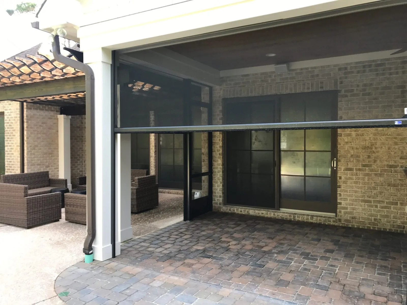 Motorized screen mid-descent over a covered patio