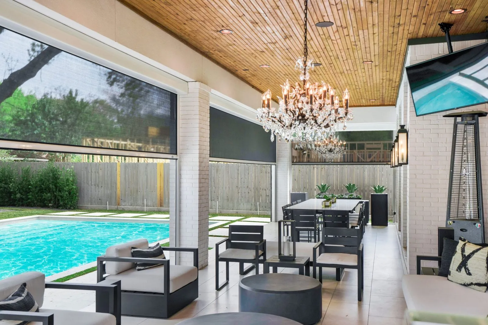 Poolside outdoor living room enclosed by motorized privacy screens